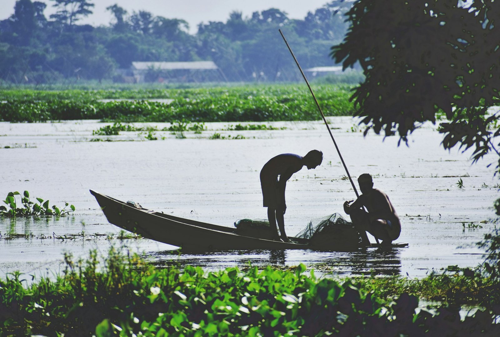 Two fishermen in a small boat on a river