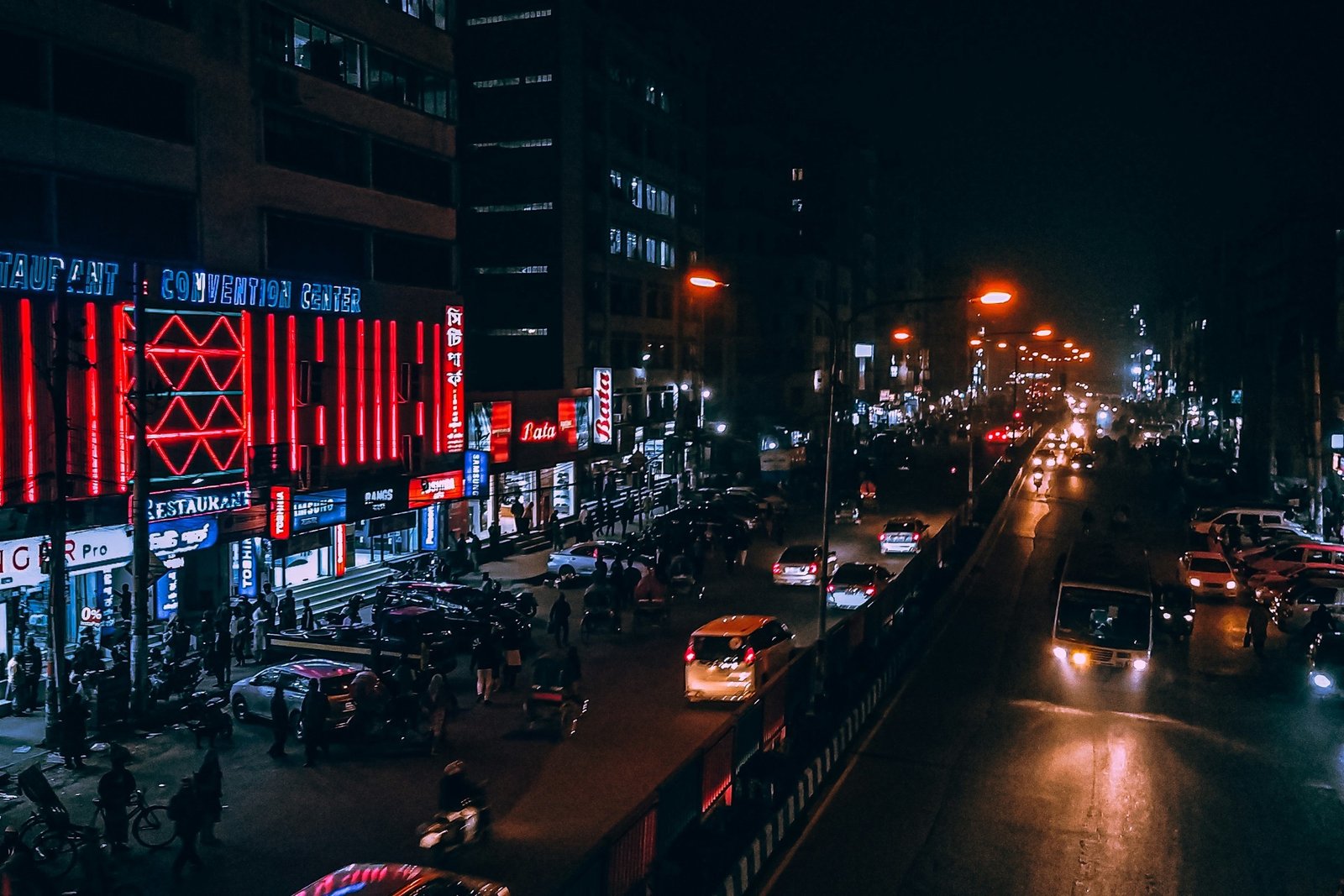 A busy city street at night with traffic and shop lights