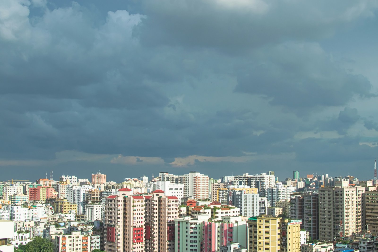 Dhaka's residential towers under monsoon clouds