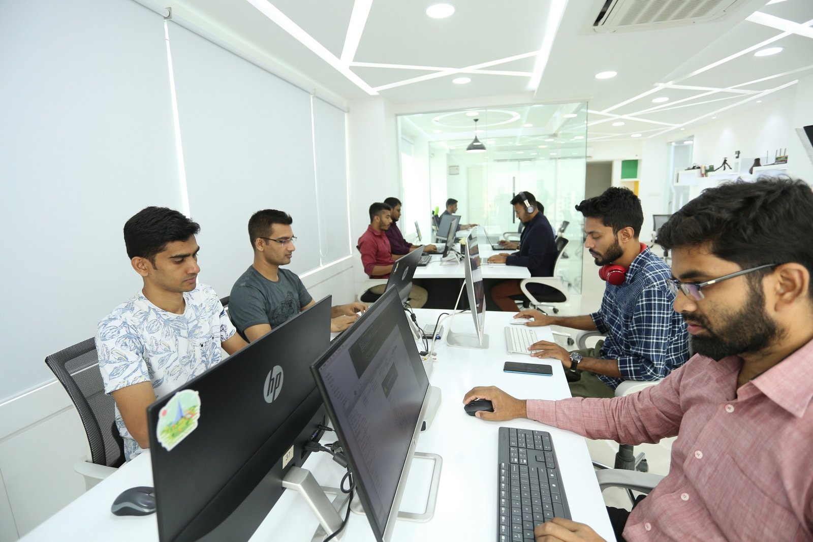 A team working at computers in a modern office in Dhaka