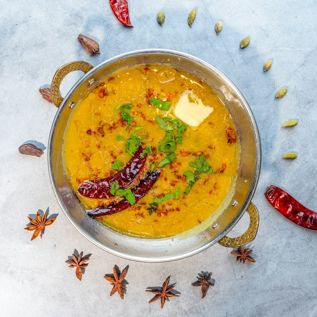A bowl of yellow chana dal with dried red chillies