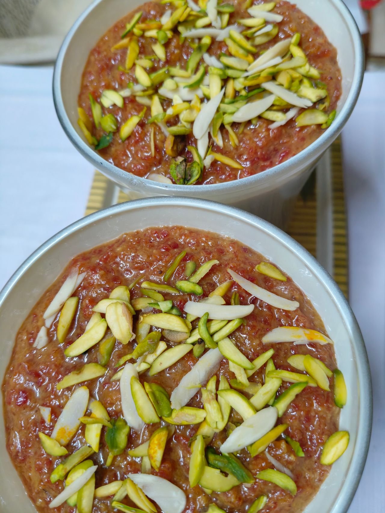 A bowl of milky shemai topped with pistachios and almonds